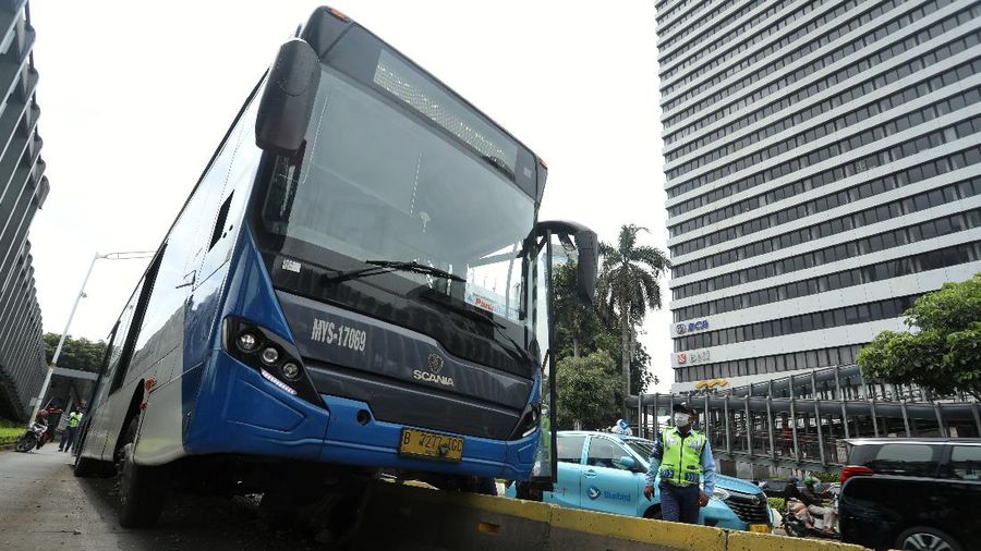 Petugas melihat kondisi bus Transjakarta yang mengalami kecelakaan di depan Ratu Plaza, Jakarta, Jumat (3/12/2021). (CNBC Indonesia/Andrean Kristianto)