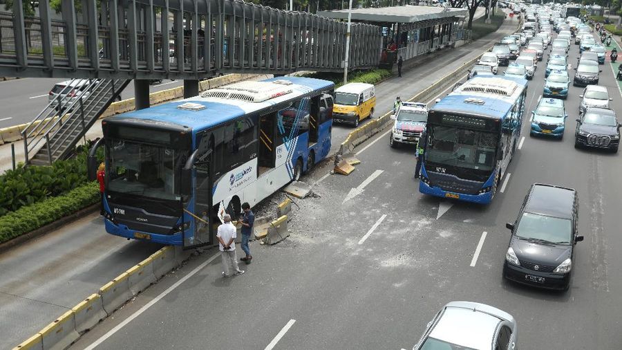 Petugas melihat kondisi bus Transjakarta yang mengalami kecelakaan di depan Ratu Plaza, Jakarta, Jumat (3/12/2021). (CNBC Indonesia/Andrean Kristianto)