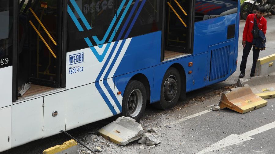 Petugas melihat kondisi bus Transjakarta yang mengalami kecelakaan di depan Ratu Plaza, Jakarta, Jumat (3/12/2021). (CNBC Indonesia/Andrean Kristianto)