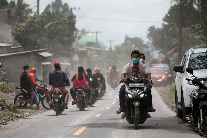 An Indonesian soldier walks past damage trucks at Sumberwuluh village following the eruption of Semeru mount volcano in Lumajang regency, East Java province, Indonesia, December 5, 2021. REUTERS/Willy Kurniawan