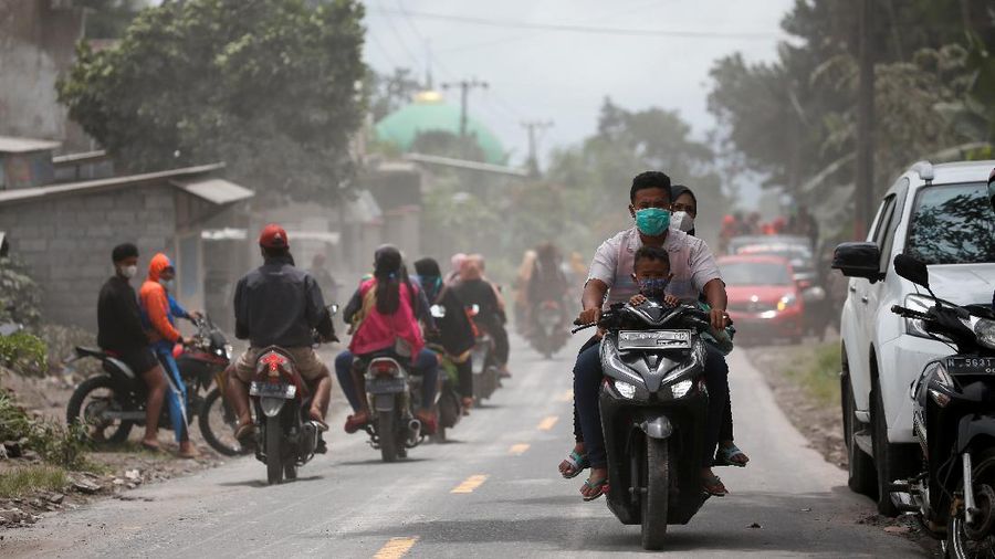 An Indonesian soldier walks past damage trucks at Sumberwuluh village following the eruption of Semeru mount volcano in Lumajang regency, East Java province, Indonesia, December 5, 2021. REUTERS/Willy Kurniawan