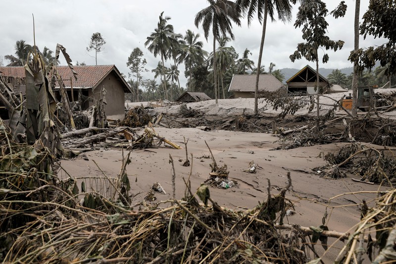 An Indonesian soldier walks past damage trucks at Sumberwuluh village following the eruption of Semeru mount volcano in Lumajang regency, East Java province, Indonesia, December 5, 2021. REUTERS/Willy Kurniawan
