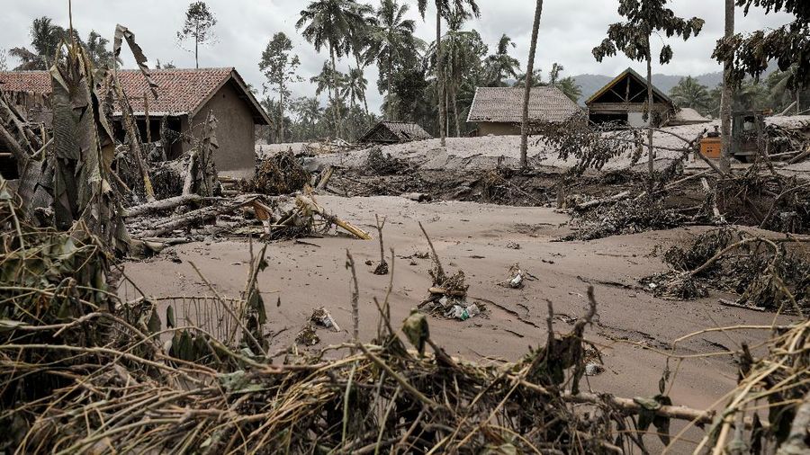 An Indonesian soldier walks past damage trucks at Sumberwuluh village following the eruption of Semeru mount volcano in Lumajang regency, East Java province, Indonesia, December 5, 2021. REUTERS/Willy Kurniawan