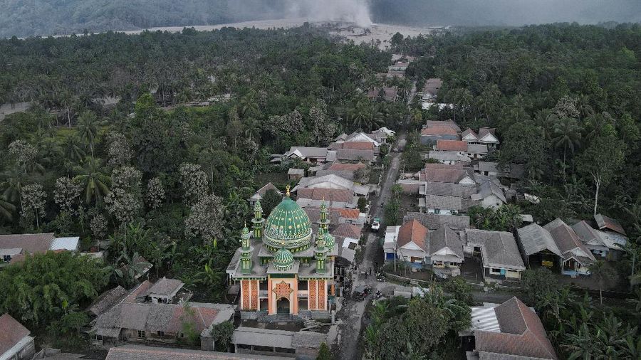 An Indonesian soldier walks past damage trucks at Sumberwuluh village following the eruption of Semeru mount volcano in Lumajang regency, East Java province, Indonesia, December 5, 2021. REUTERS/Willy Kurniawan