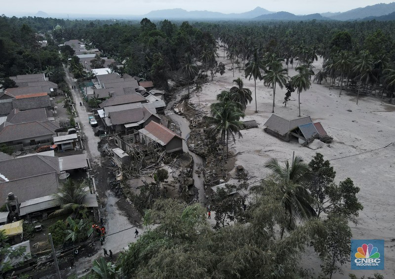 An Indonesian soldier walks past damage trucks at Sumberwuluh village following the eruption of Semeru mount volcano in Lumajang regency, East Java province, Indonesia, December 5, 2021. REUTERS/Willy Kurniawan