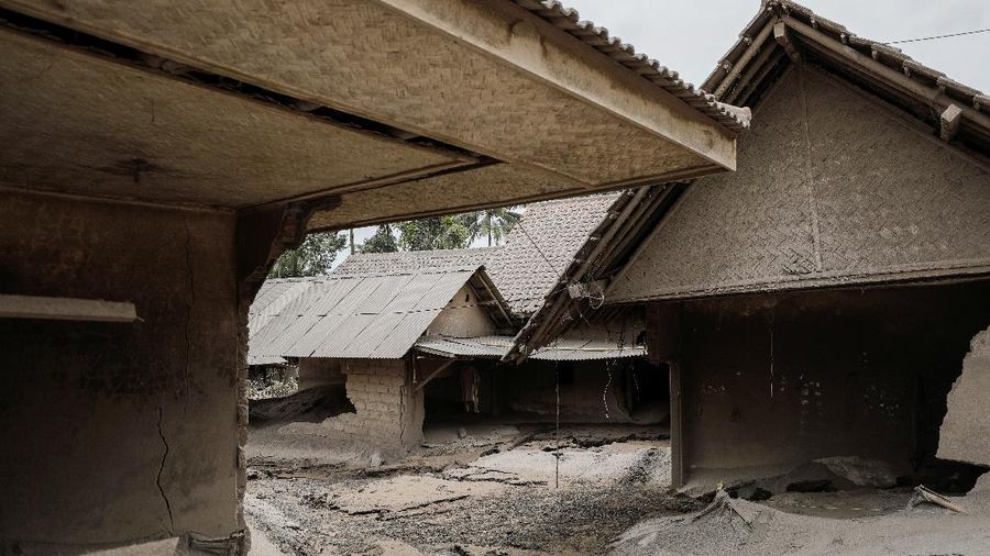 An Indonesian soldier walks past damage trucks at Sumberwuluh village following the eruption of Semeru mount volcano in Lumajang regency, East Java province, Indonesia, December 5, 2021. REUTERS/Willy Kurniawan
