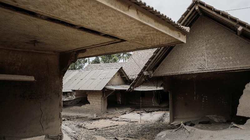 An Indonesian soldier walks past damage trucks at Sumberwuluh village following the eruption of Semeru mount volcano in Lumajang regency, East Java province, Indonesia, December 5, 2021. REUTERS/Willy Kurniawan