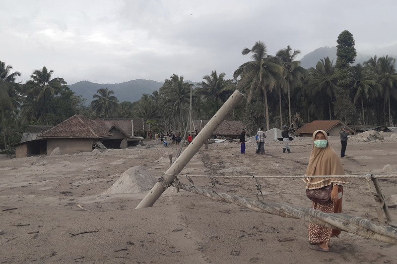 Indonesian rescuers search for victims in an area affected by the eruption of Mount Semeru in Lumajang, East Java, Indonesia, Sunday, Dec 5, 2021. Indonesia's highest volcano on Java island has spewed thick columns of ash, searing gas and lava down its slopes in a sudden eruption triggered by heavy rains.  (AP Photo/Rokhmad)
