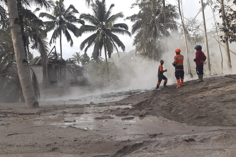 Indonesian rescuers search for victims in an area affected by the eruption of Mount Semeru in Lumajang, East Java, Indonesia, Sunday, Dec 5, 2021. Indonesia's highest volcano on Java island has spewed thick columns of ash, searing gas and lava down its slopes in a sudden eruption triggered by heavy rains.  (AP Photo/Rokhmad)