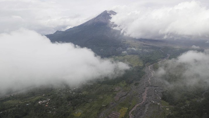 A village is covered in ash from the eruption of Mount Semeru in Lumajang district, East Java province, Indonesia, Monday, Dec. 6, 2021. The highest volcano on Java island spewed thick columns of ash into the sky in a sudden eruption Saturday triggered by heavy rains. Villages and nearby towns were blanketed and several hamlets buried under tons of mud from volcanic debris. (AP Photo/Trisnadi)