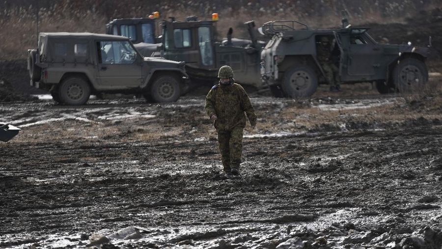 A member of Japanese Ground-Self Defense Force (JGDDF) walks in muddy field during the annual drill with live ammunitions exercise at Minami Eniwa Camp Monday, Dec. 6, 2021, in Eniwa, on the northern Japan island of Hokkaido. Dozens of tanks and hundreds of soldiers fired explosives and machine guns in drills Monday on Japan's northern island of Hokkaido, a main stronghold for a nation that is perhaps the world's least-known military powerhouse.
(AP Photo/Eugene Hoshiko)
