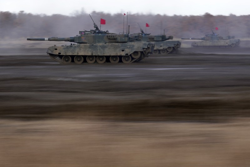 Japan Military Japanese Ground-Self Defense Force (JGDDF) Type 90 tanks drive toward a target during the annual drill with live ammunitions exercise at Minami Eniwa Camp Monday, Dec. 6, 2021, in Eniwa, northern Japan of Hokkaido. Dozens of tanks are rolling over the next two weeks on Hokkaido, a main military stronghold for a country with perhaps the world's most little known yet powerful army. (AP Photo/Eugene Hoshiko)