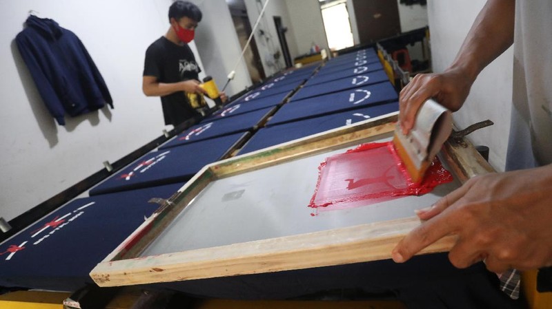 Pekerja menyelesaikan proses sablon baju di kawasan Pamulang, Tangerang Selatan, Senin (6/12/2021).  Harga kapas acuan dunia berhasil melesat hingga level tertingginya dalam satu dekade terakhir, karena beberapa faktor yang mempengaruhinya. (CNBC Indonesia/Andrean Kristianto)