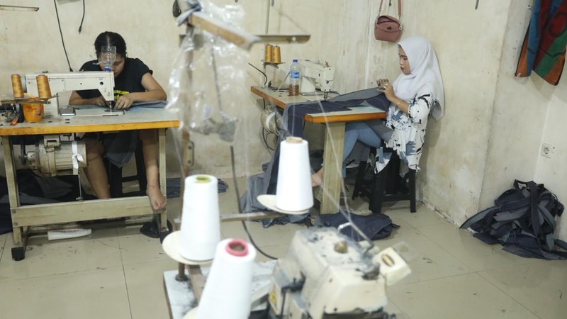 Pekerja menyelesaikan proses sablon baju di kawasan Pamulang, Tangerang Selatan, Senin (6/12/2021).  Harga kapas acuan dunia berhasil melesat hingga level tertingginya dalam satu dekade terakhir, karena beberapa faktor yang mempengaruhinya. (CNBC Indonesia/Andrean Kristianto)