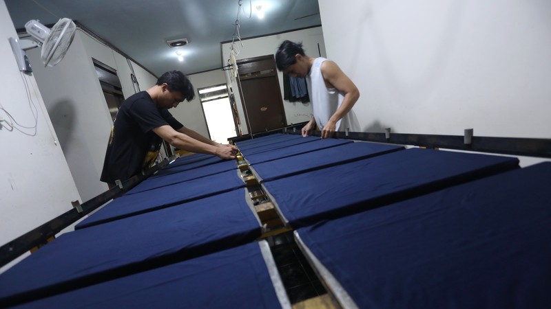 Pekerja menyelesaikan proses sablon baju di kawasan Pamulang, Tangerang Selatan, Senin (6/12/2021).  Harga kapas acuan dunia berhasil melesat hingga level tertingginya dalam satu dekade terakhir, karena beberapa faktor yang mempengaruhinya. (CNBC Indonesia/Andrean Kristianto)