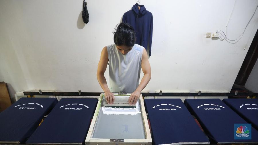 Pekerja menyelesaikan proses sablon baju di kawasan Pamulang, Tangerang Selatan, Senin (6/12/2021).  Harga kapas acuan dunia berhasil melesat hingga level tertingginya dalam satu dekade terakhir, karena beberapa faktor yang mempengaruhinya. (CNBC Indonesia/Andrean Kristianto)