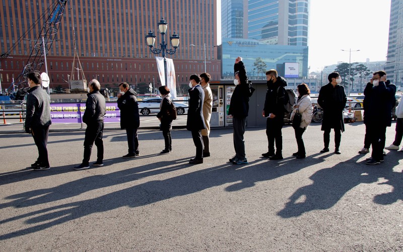 People queue in line to wait for the coronavirus testing at a makeshift testing site in Seoul, South Korea, Wednesday, Dec. 8, 2021. (AP Photo/Ahn Young-joon).