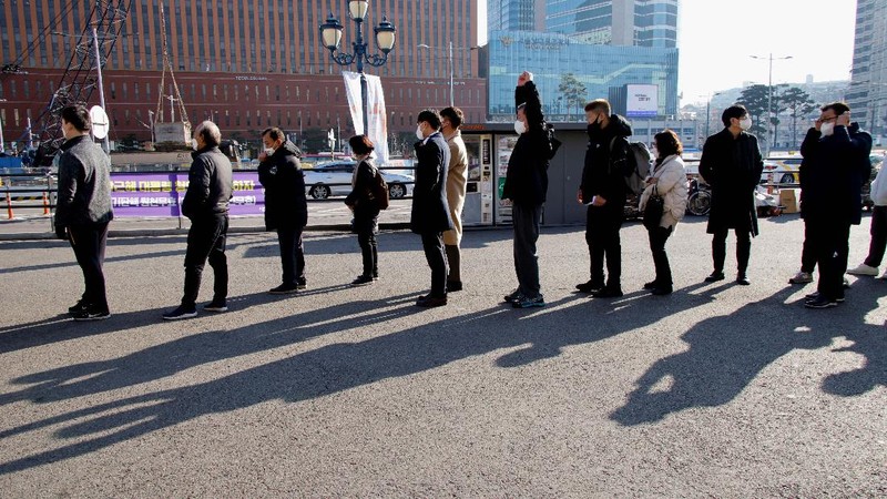 People queue in line to wait for the coronavirus testing at a makeshift testing site in Seoul, South Korea, Wednesday, Dec. 8, 2021. (AP Photo/Ahn Young-joon).