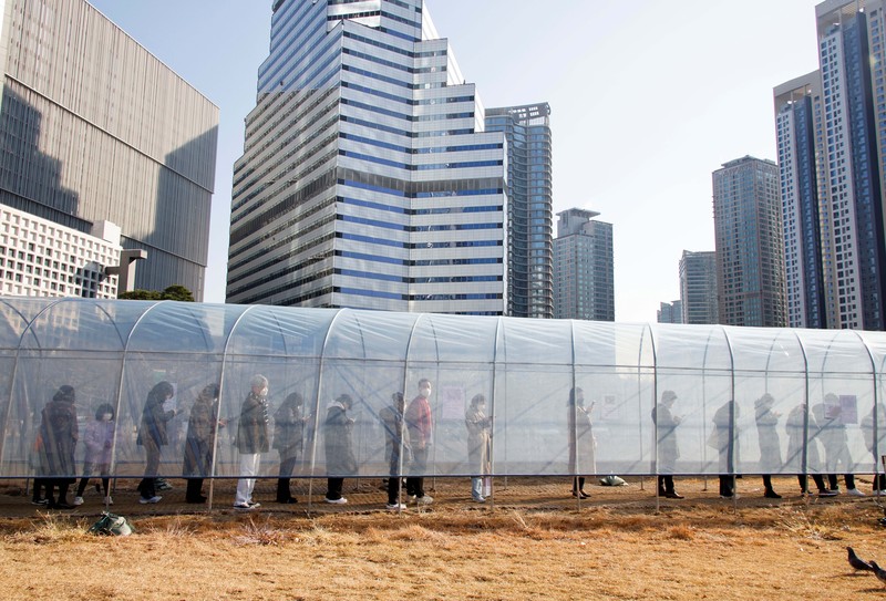 Virus Outbreak South Korea People queue in line to wait for the coronavirus testing at a makeshift testing site in Seoul, South Korea, Wednesday, Dec. 8, 2021. (AP Photo/Ahn Young-joon).