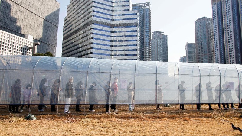People queue in line to wait for the coronavirus testing at a makeshift testing site in Seoul, South Korea, Wednesday, Dec. 8, 2021. (AP Photo/Ahn Young-joon).