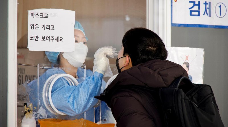 People queue in line to wait for the coronavirus testing at a makeshift testing site in Seoul, South Korea, Wednesday, Dec. 8, 2021. (AP Photo/Ahn Young-joon).