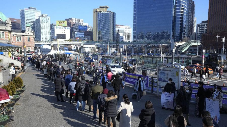 People queue in line to wait for the coronavirus testing at a makeshift testing site in Seoul, South Korea, Wednesday, Dec, 8, 2021. New coronavirus infections in South Korea exceeded 7,000 for the first time since the start of the pandemic on Wednesday as hours-long lines snaked around testing stations in the capital Seoul amid a worsening virus crisis. (AP Photo/Ahn Young-joon).