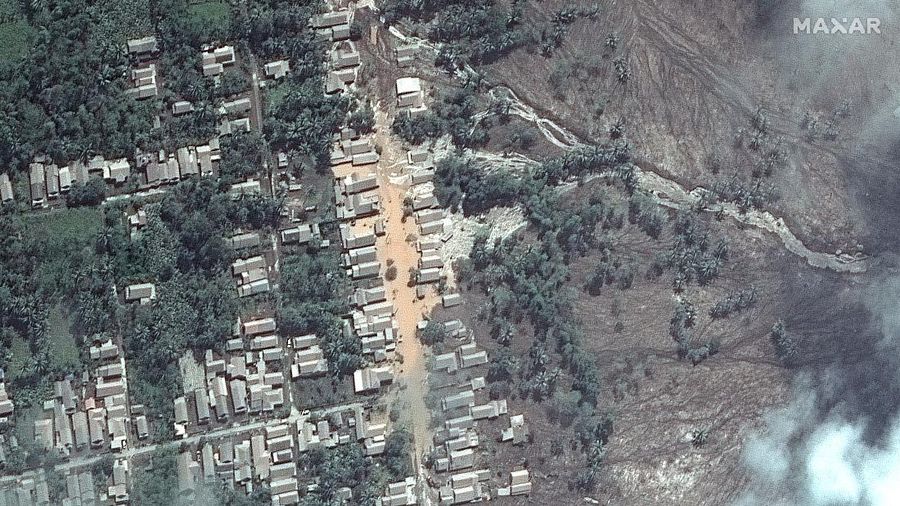 A combination of two satellite images provided by Satellite image ©2021 Maxar Technologies from Nov. 15, 2019, left, and Dec. 8, 2021, shows the mud and ash flows that swept through the area of Roboan, East Java, Indonesia from the eruption of nearby volcano Mount Semeru. The volcano erupted on Saturday, killing at dozens of people with searing ash and gas that blanketed several villages around it. (Maxar Technologies via AP)