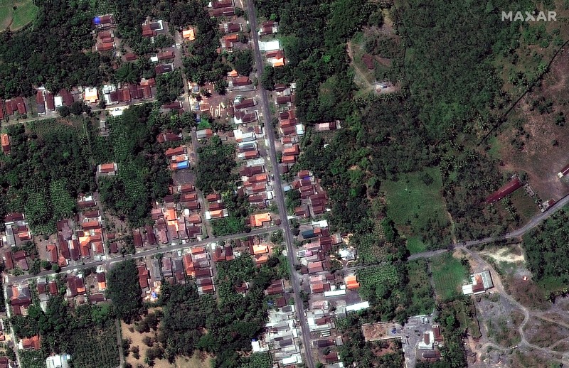 A combination of two satellite images provided by Satellite image ©2021 Maxar Technologies from Nov. 15, 2019, left, and Dec. 8, 2021, shows the mud and ash flows that swept through the area of Roboan, East Java, Indonesia from the eruption of nearby volcano Mount Semeru. The volcano erupted on Saturday, killing at dozens of people with searing ash and gas that blanketed several villages around it. (Maxar Technologies via AP)
