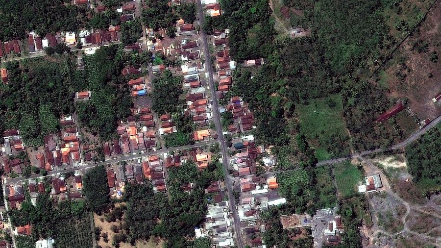 A combination of two satellite images provided by Satellite image ©2021 Maxar Technologies from Nov. 15, 2019, left, and Dec. 8, 2021, shows the mud and ash flows that swept through the area of Roboan, East Java, Indonesia from the eruption of nearby volcano Mount Semeru. The volcano erupted on Saturday, killing at dozens of people with searing ash and gas that blanketed several villages around it. (Maxar Technologies via AP)