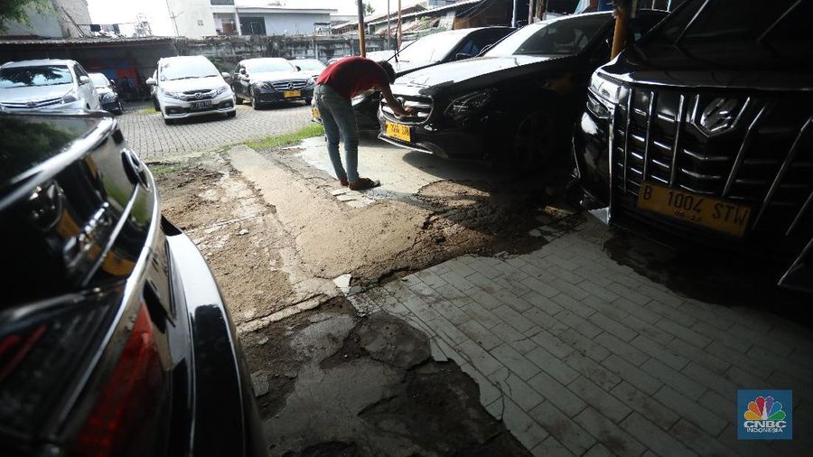 Pekerja merapihkan mobil eks-taksi yang akan dijual di showroom mobil Bluebird di kawasan Warung Buncit, Jakarta Selatan, Kamis (9/12/2021).  Mobil bekas armada taksi merupakan alternatif menarik bagi Anda yang berminat untuk mendapatkan kendaraan dengan harga lebih terjangkau. (CNBC Indonesia/Andrean Kristianto)