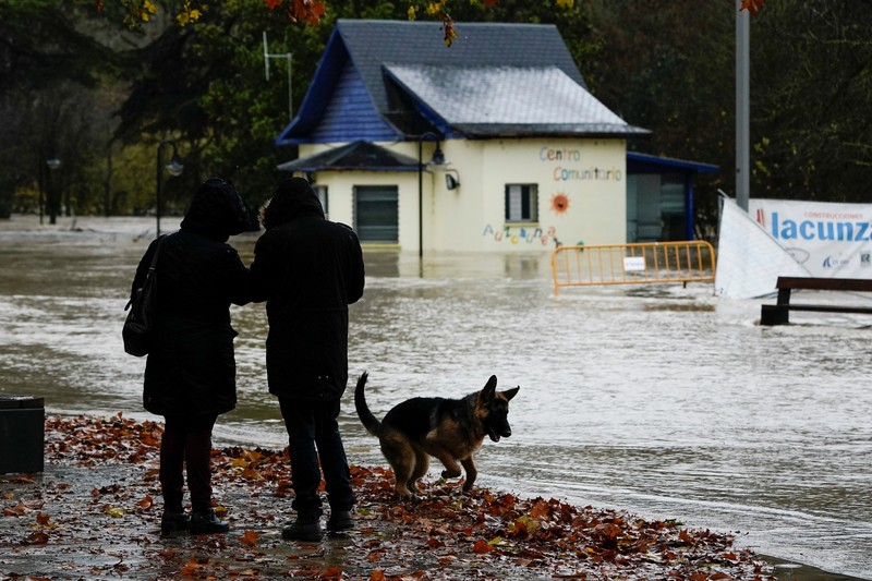 SPAIN-WEATHER/ A man rides a kayak on a flooded road, following heavy rainfall in Pamplona, Spain, December 10, 2021. REUTERS/Vincent West