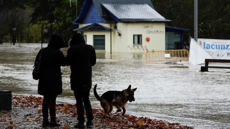 A man rides a kayak on a flooded road, following heavy rainfall in Pamplona, Spain, December 10, 2021. REUTERS/Vincent West