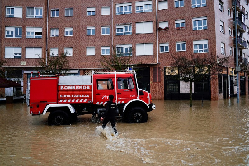 SPAIN-WEATHER/ A man rides a kayak on a flooded road, following heavy rainfall in Pamplona, Spain, December 10, 2021. REUTERS/Vincent West