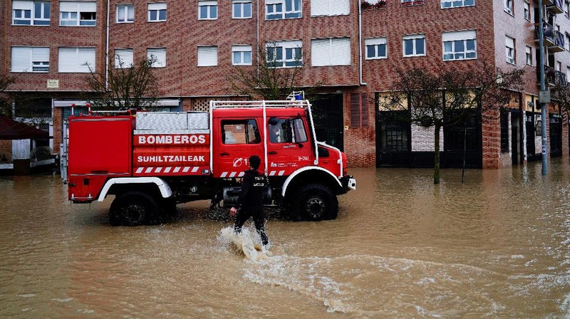 A man rides a kayak on a flooded road, following heavy rainfall in Pamplona, Spain, December 10, 2021. REUTERS/Vincent West
