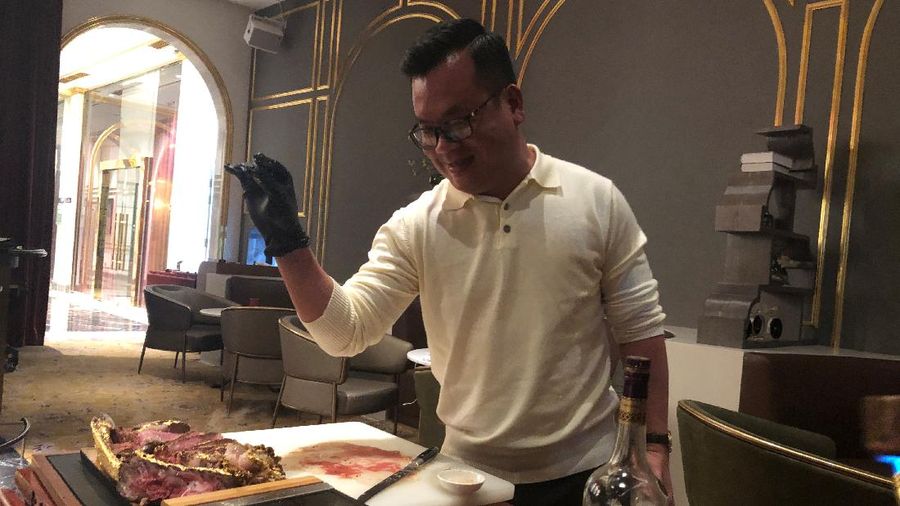 A chef serves a gold leaf-coated steak to a Vietnam War veteran, tapping in on a wave of publicity after a government minister was caught on camera being fed the dish at a London restaurant, at a Dolce By Wyndham Hanoi Golden Lake hotel, in Hanoi, Vietnam December 4, 2021. Picture taken December 4, 2021. REUTERS/Minh Nguyen