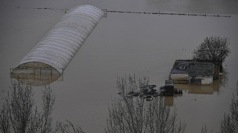 A man rides a kayak on a flooded road, following heavy rainfall in Pamplona, Spain, December 10, 2021. REUTERS/Vincent West