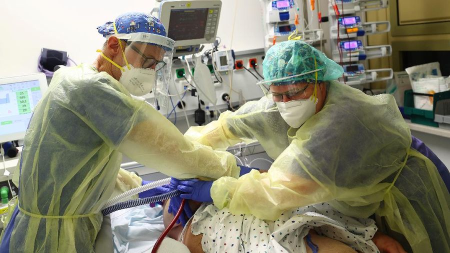 Medical staff transfer a patient in need of an ECMO (extracorporeal membrane oxygenation) life support unit for a CT examination at the coronavirus disease (COVID-19) Intensive Care Unit (ICU) of the 