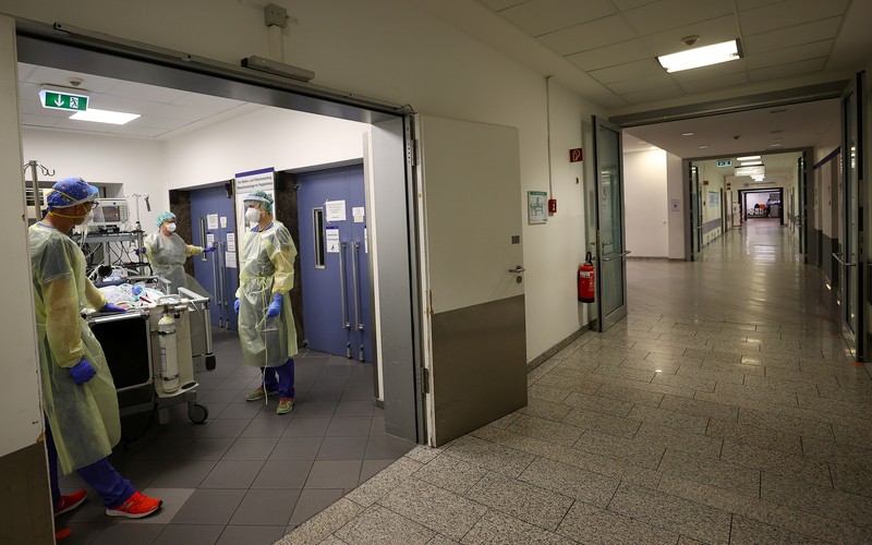 Medical staff transfer a patient in need of an ECMO (extracorporeal membrane oxygenation) life support unit for a CT examination at the coronavirus disease (COVID-19) Intensive Care Unit (ICU) of the 