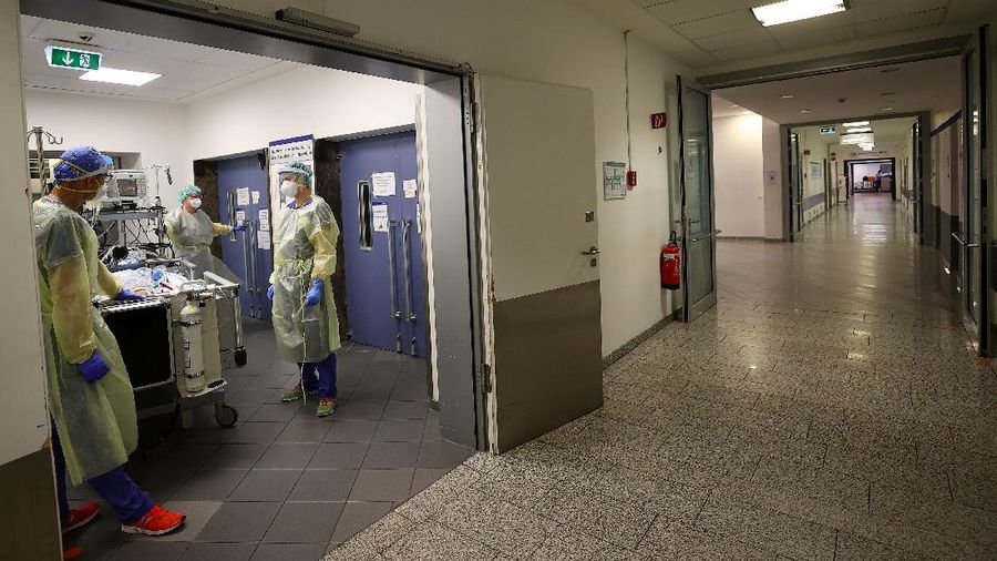 Medical staff transfer a patient in need of an ECMO (extracorporeal membrane oxygenation) life support unit for a CT examination at the coronavirus disease (COVID-19) Intensive Care Unit (ICU) of the 