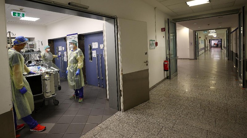 Medical staff transfer a patient in need of an ECMO (extracorporeal membrane oxygenation) life support unit for a CT examination at the coronavirus disease (COVID-19) Intensive Care Unit (ICU) of the 