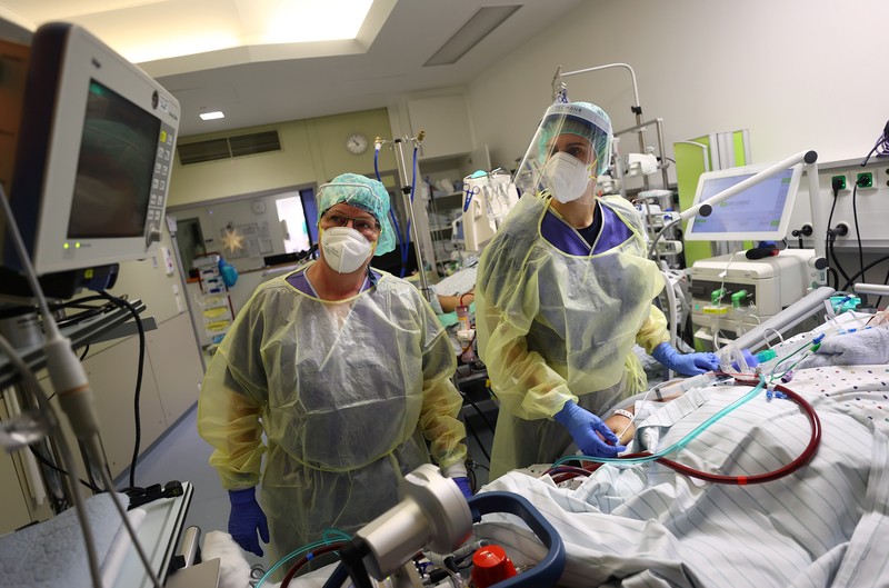 Medical staff transfer a patient in need of an ECMO (extracorporeal membrane oxygenation) life support unit for a CT examination at the coronavirus disease (COVID-19) Intensive Care Unit (ICU) of the 