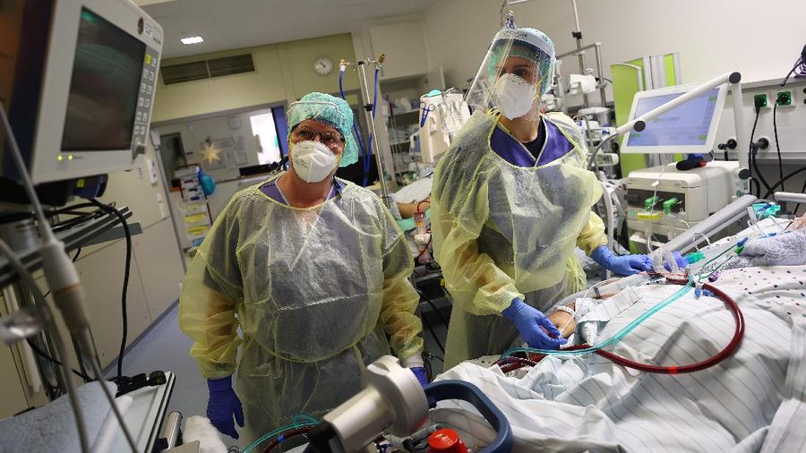 Medical staff transfer a patient in need of an ECMO (extracorporeal membrane oxygenation) life support unit for a CT examination at the coronavirus disease (COVID-19) Intensive Care Unit (ICU) of the 