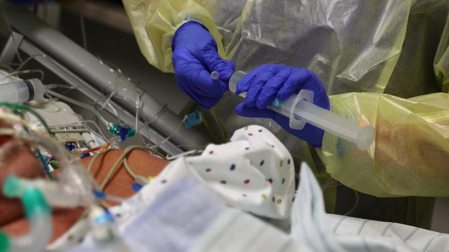 Medical staff transfer a patient in need of an ECMO (extracorporeal membrane oxygenation) life support unit for a CT examination at the coronavirus disease (COVID-19) Intensive Care Unit (ICU) of the 
