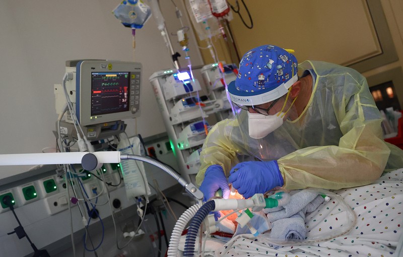 Medical staff transfer a patient in need of an ECMO (extracorporeal membrane oxygenation) life support unit for a CT examination at the coronavirus disease (COVID-19) Intensive Care Unit (ICU) of the 