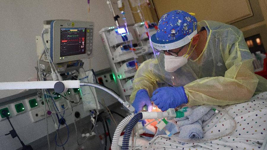 Medical staff transfer a patient in need of an ECMO (extracorporeal membrane oxygenation) life support unit for a CT examination at the coronavirus disease (COVID-19) Intensive Care Unit (ICU) of the 