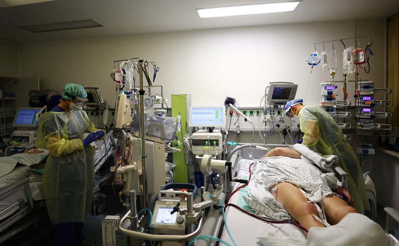 Medical staff transfer a patient in need of an ECMO (extracorporeal membrane oxygenation) life support unit for a CT examination at the coronavirus disease (COVID-19) Intensive Care Unit (ICU) of the 