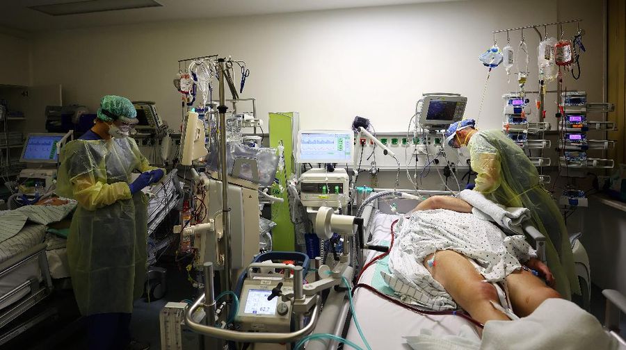 Medical staff transfer a patient in need of an ECMO (extracorporeal membrane oxygenation) life support unit for a CT examination at the coronavirus disease (COVID-19) Intensive Care Unit (ICU) of the 