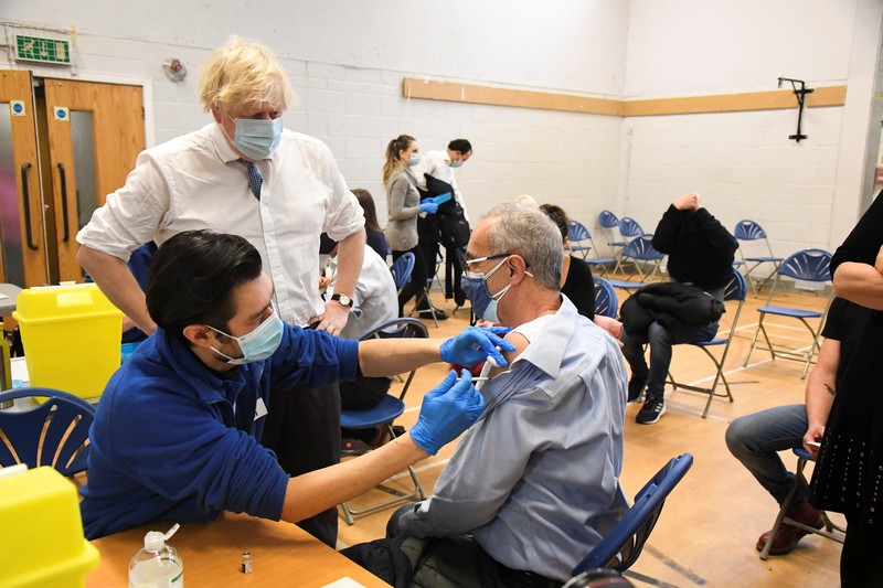 HEALTH-CORONAVIRUS/BRITAIN People queue outside a coronavirus disease (COVID-19) vaccination centre at a church in London, Britain, December 13, 2021. REUTERS/Hannah McKay