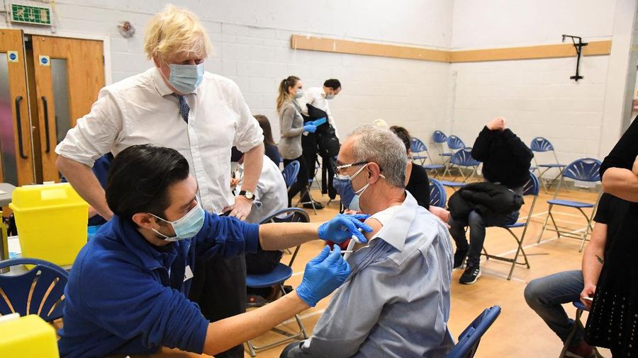 People queue outside a coronavirus disease (COVID-19) vaccination centre at a church in London, Britain, December 13, 2021. REUTERS/Hannah McKay