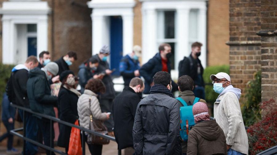 People queue outside a coronavirus disease (COVID-19) vaccination centre at a church in London, Britain, December 13, 2021. REUTERS/Hannah McKay